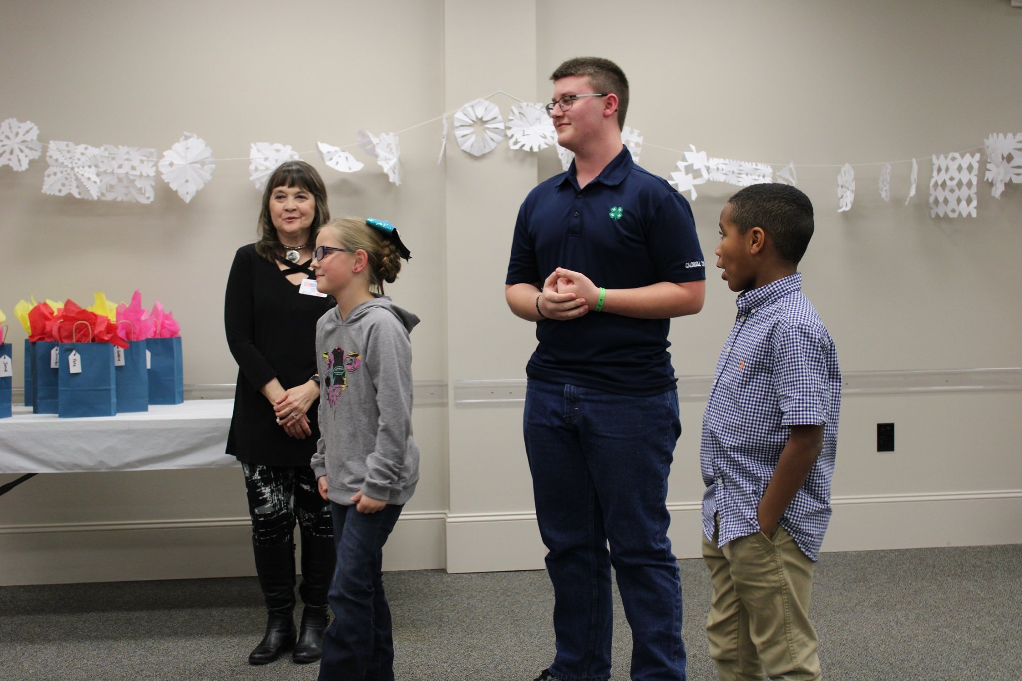 From left to right, Diana Ford assists with recognition of 4-H members Peyton Taylor, Nolan Wallace and Michael Wallace during the 2020 achievement celebration. 