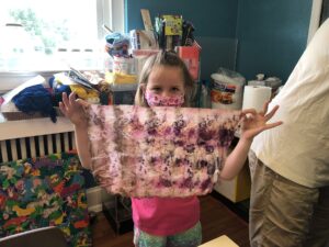 Mollie Bryant poses with her dyed cloth during Art Outside in July. Her group learned about natural dyes during the project.