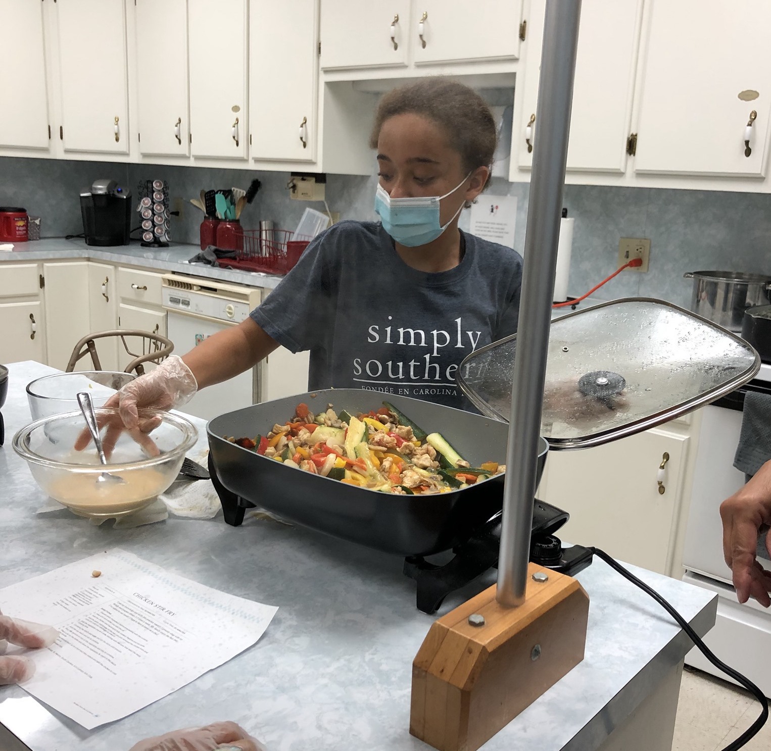 Zoey Woods prepares chicken stir fry at a Cooking 4-H Club event in July 2021.