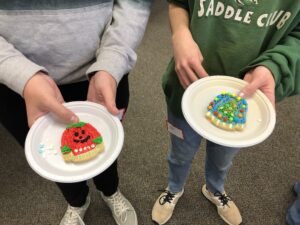 Two 4-H members pose with their decorated cookies at the Holiday Crafts event in December 2021.