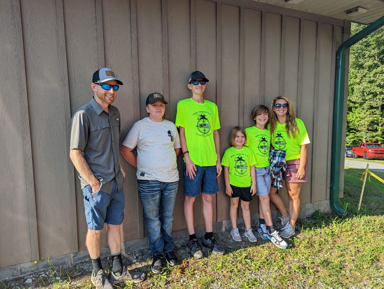 Four members of the Appalachian Aces 4-H Club pose together before competition at the West Regional 4-H Shooting Sports Tournament on August 13. From left to right stands Derrick Baker, Elijah Dillon, Jaxson Price, Cora Baker, Lawson Baker and Jennifer Baker.