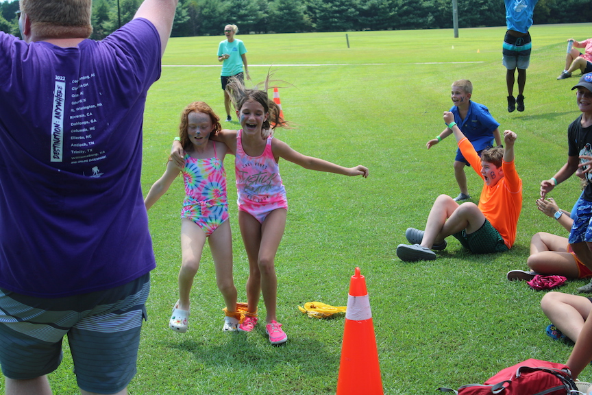 color game participants race toward the finish line as the other campers go wild cheering them on