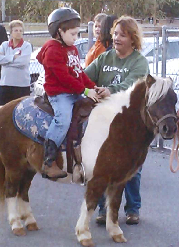 Lisa Deal works with a beginning rider, Benjamin Joplin, in 2012.
