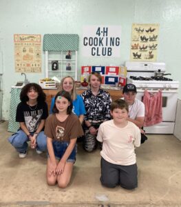 4-H cooking club members pose in front of their booth.