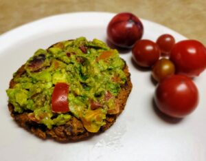 sweet potato burger on plate with side of tomatoes